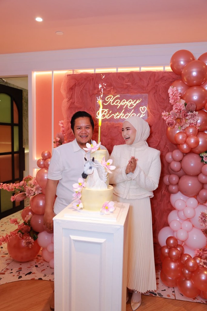 Pink fairytale first-birthday styling with organic balloon garlands, a castle cake and a neon Happy Birthday wall.