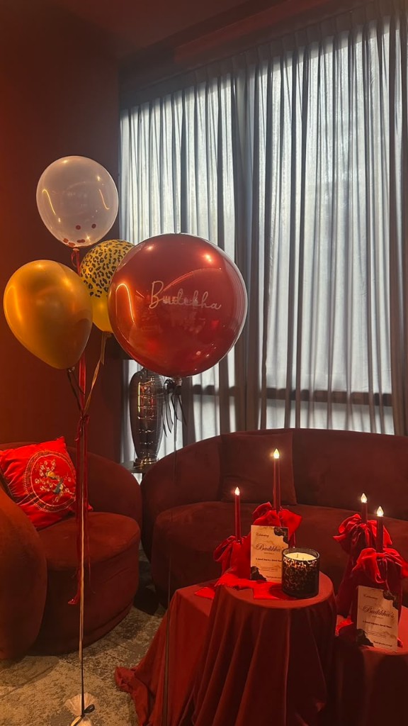 Intimate burgundy and gold surprise styling with personalised balloons and candlelight.